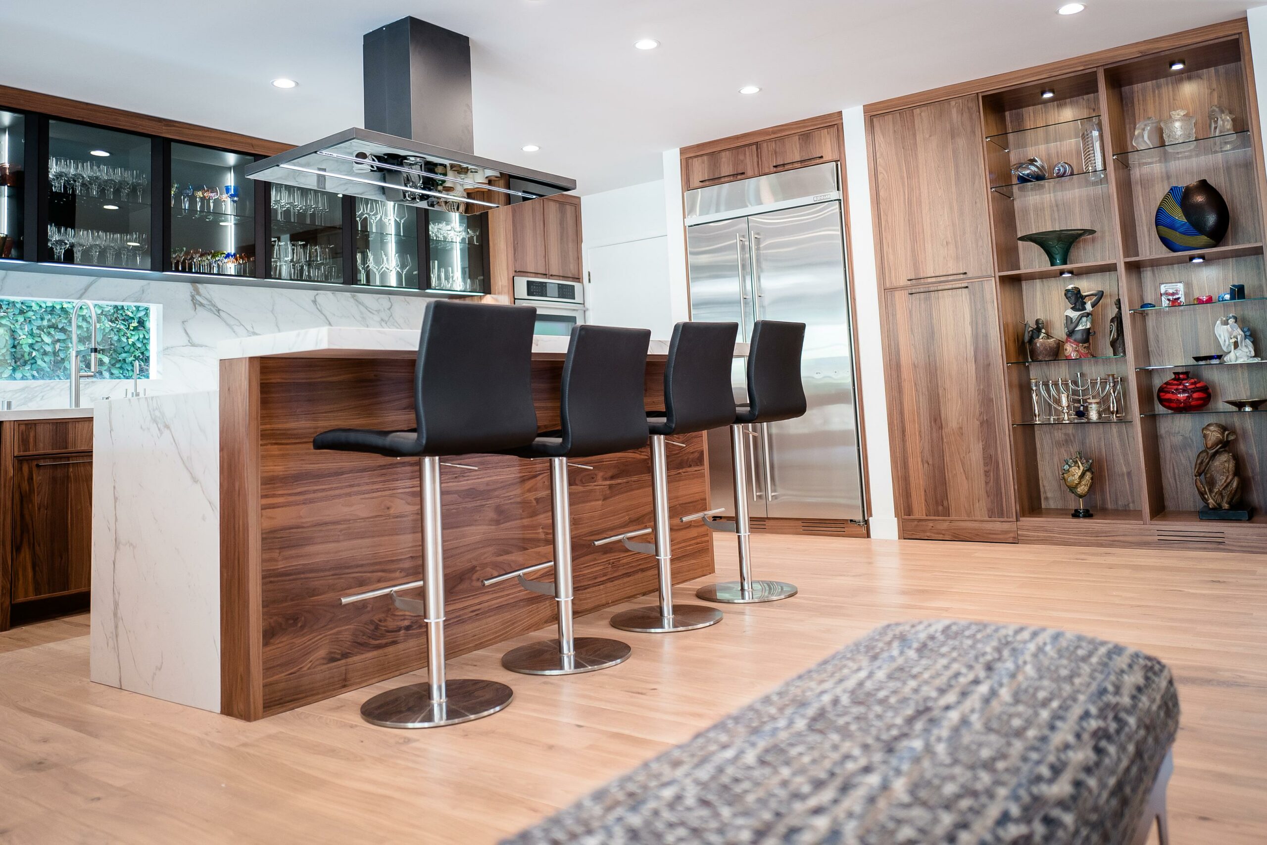 Modern kitchen interior with island and bar stools.