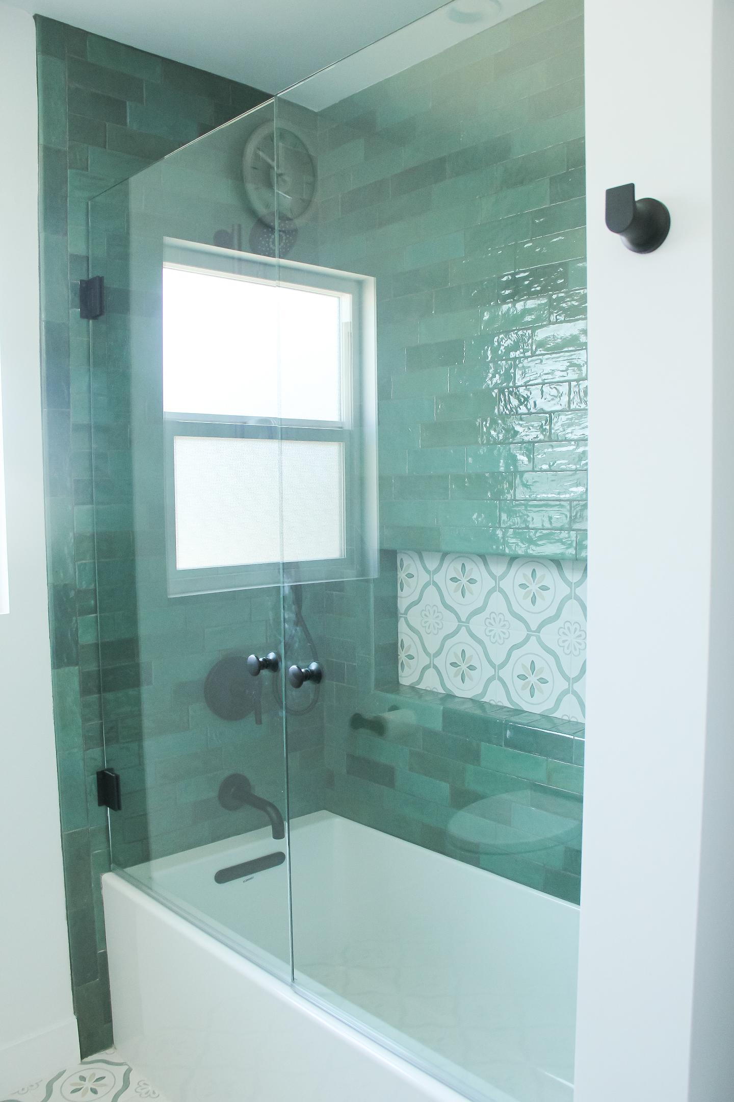 Modern bathroom with green tile shower enclosure.