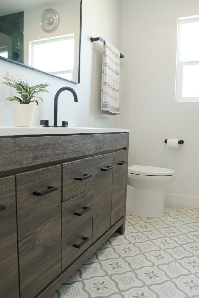 Modern bathroom with vanity and patterned tile flooring.