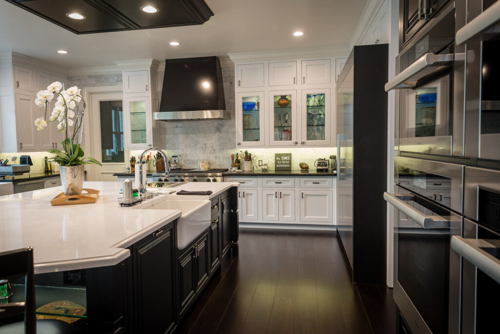 Modern kitchen with white cabinets and dark wood floor.
