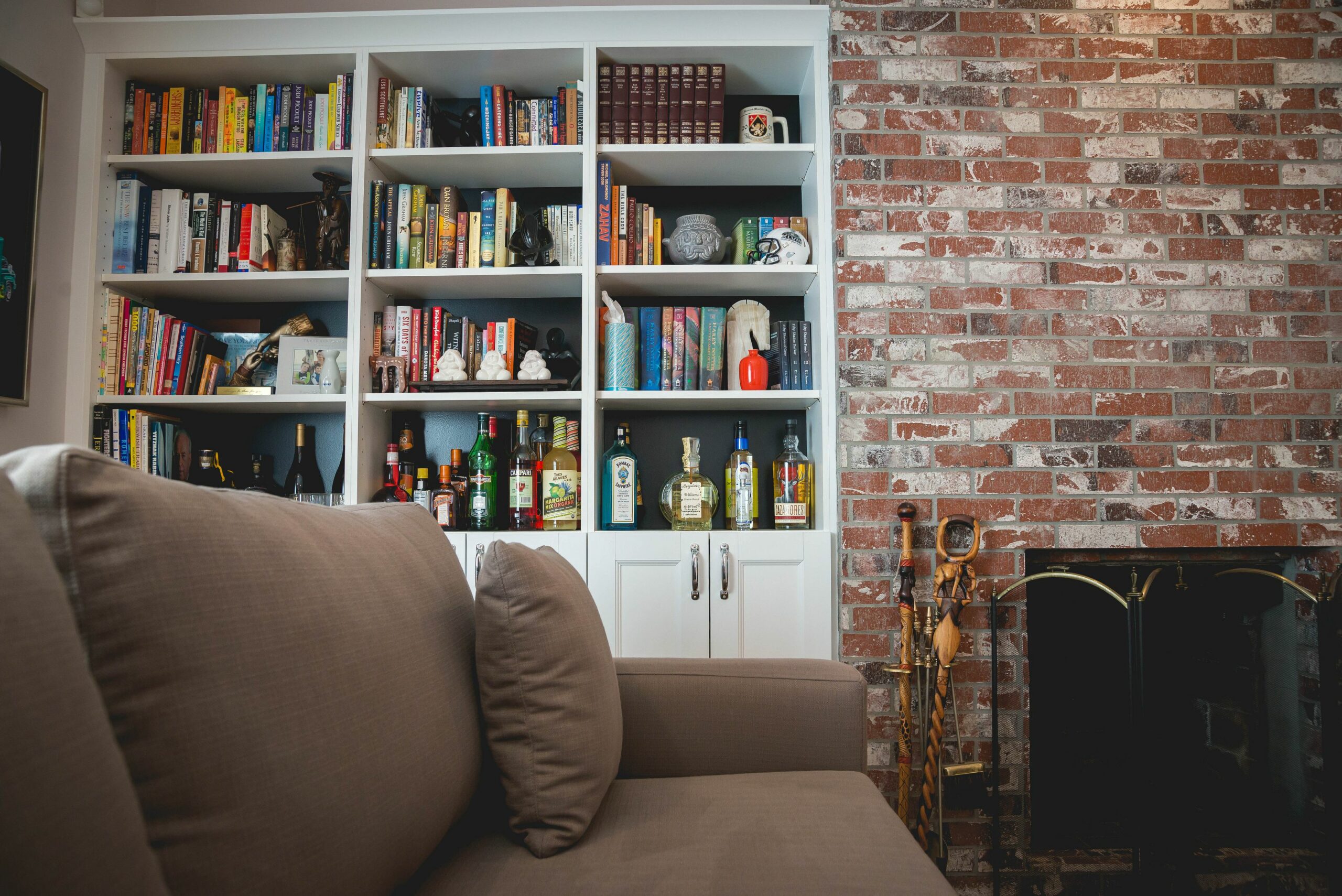 Cozy living room with bookshelves and brick fireplace.