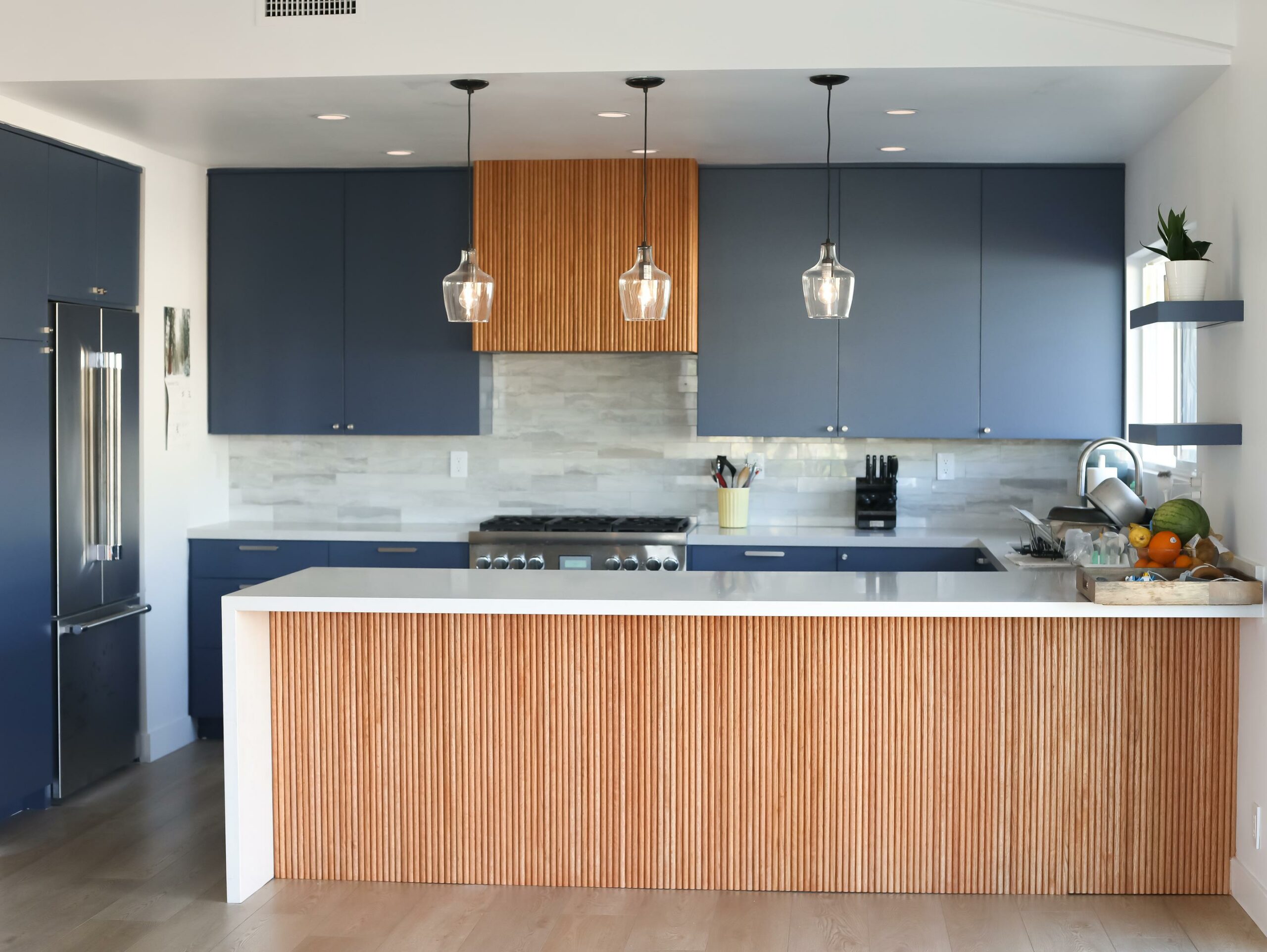 Modern kitchen interior with blue cabinets and pendant lights