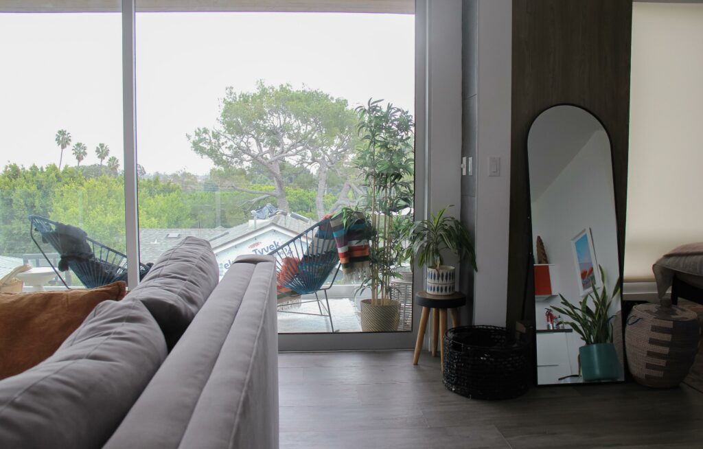 Modern living room with large windows and plants.
