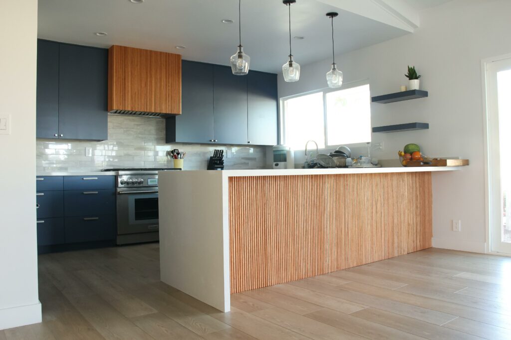 Modern kitchen interior with blue cabinets and wood accents.