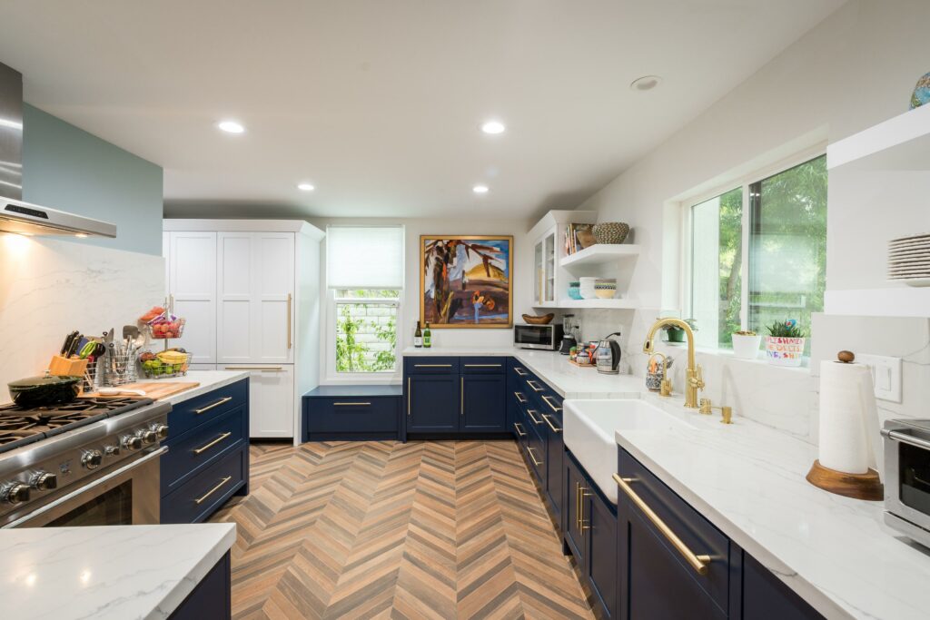 Modern kitchen with herringbone wood floor and blue cabinets.