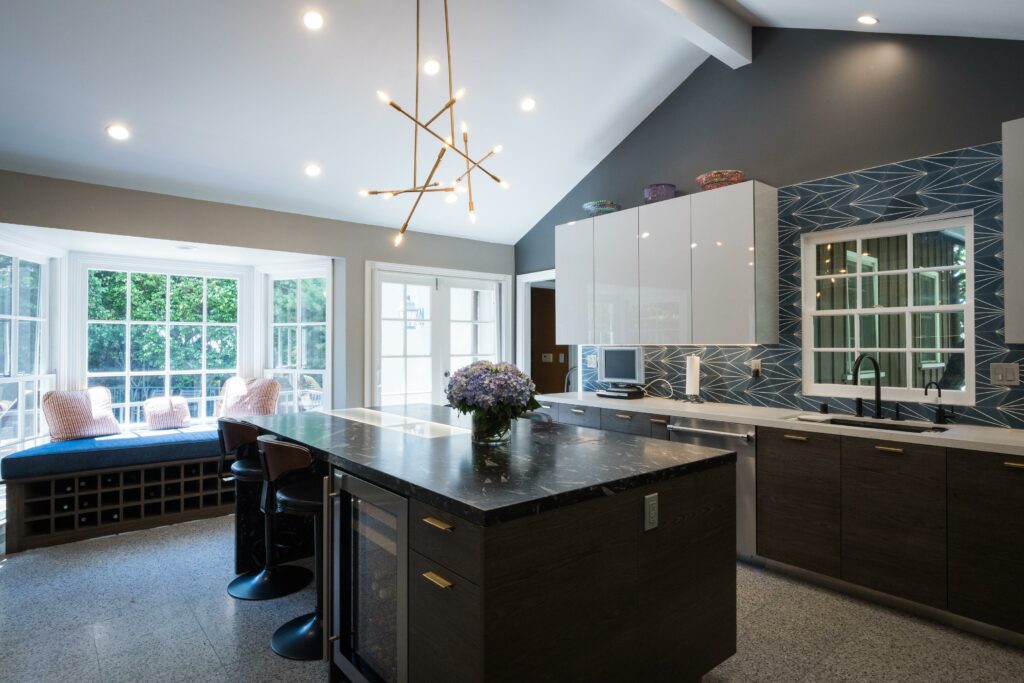 Modern kitchen interior with island and pendant lights.