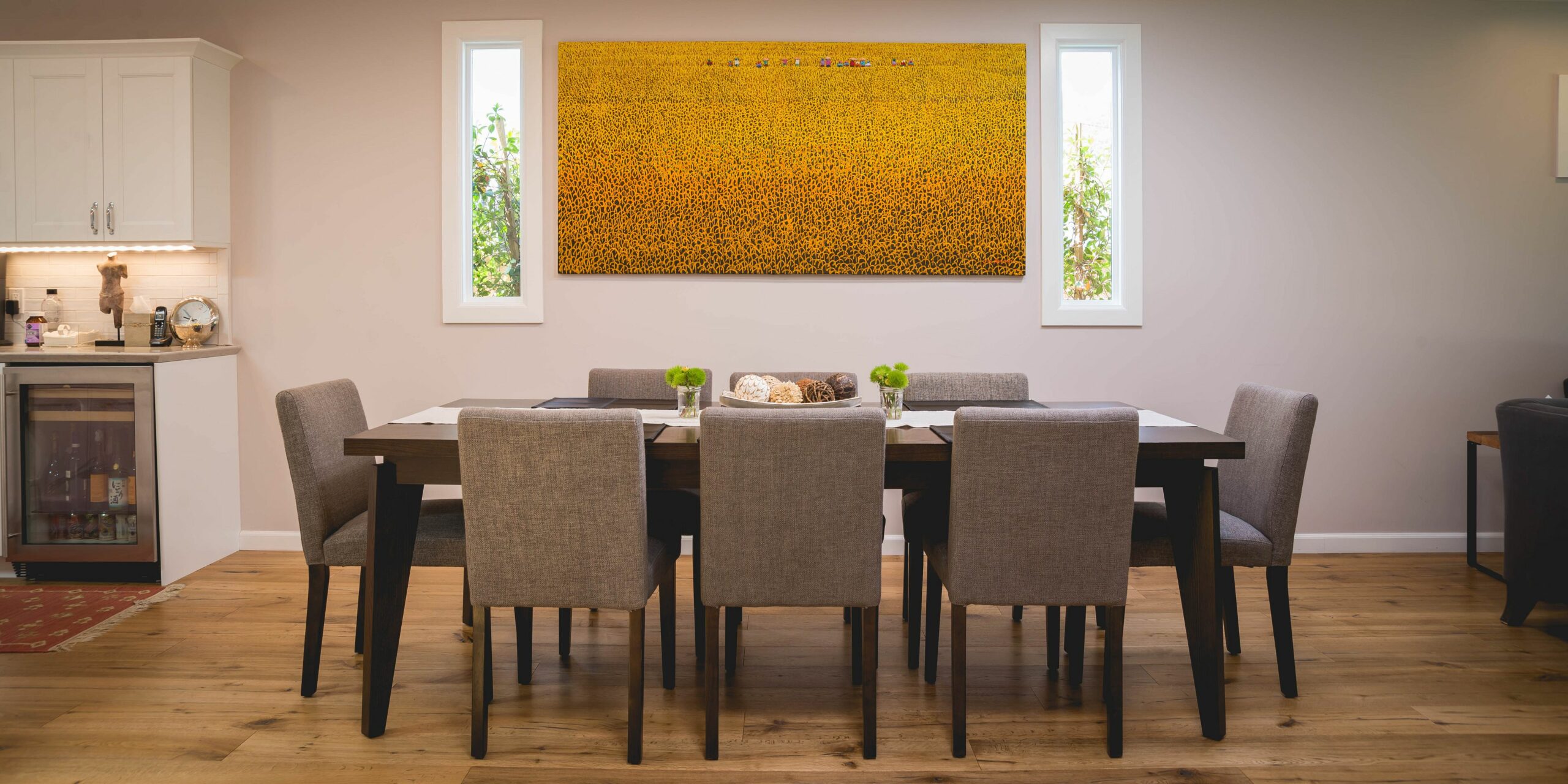 Modern dining room with large yellow artwork.