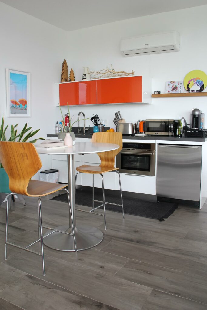 Modern kitchen interior with orange cabinets and wooden accents.