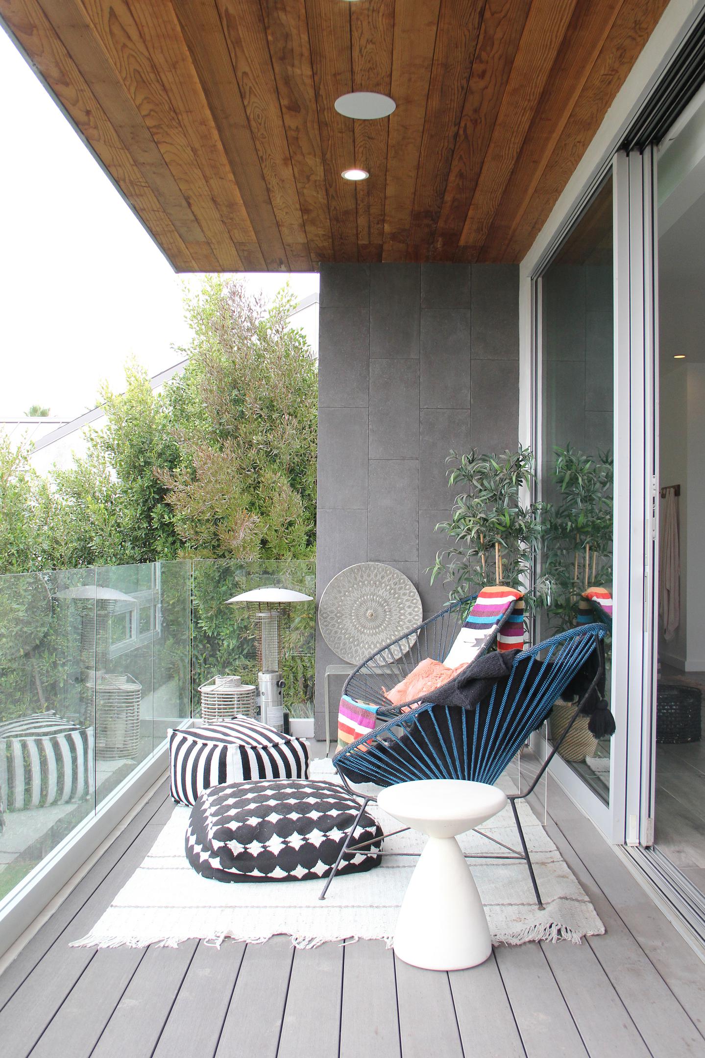 Modern patio with stylish furniture and greenery.