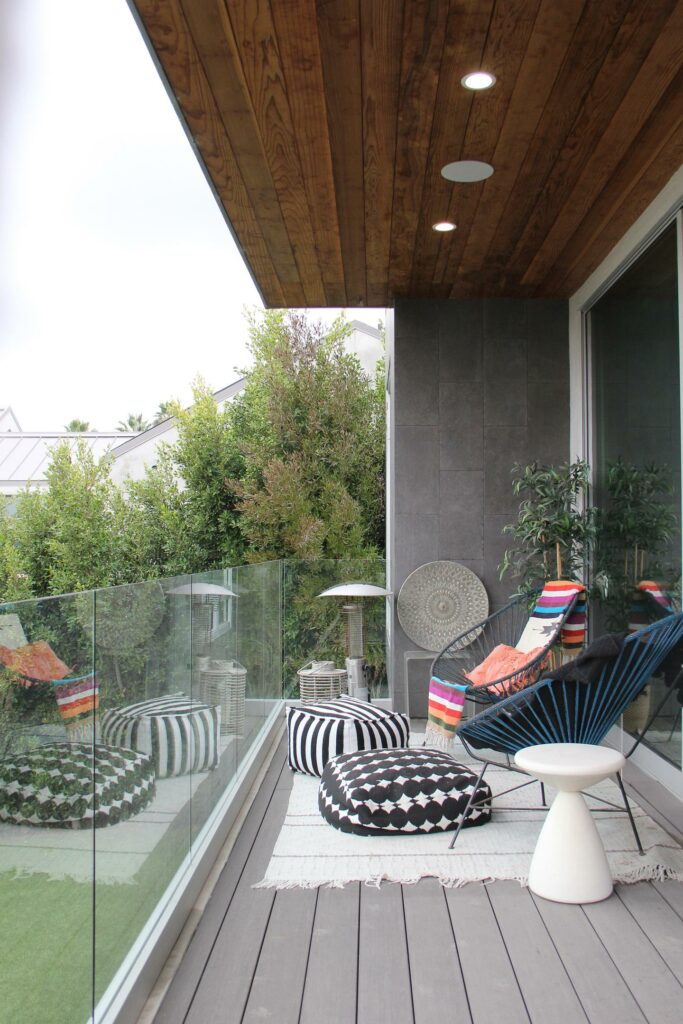 Cozy balcony with modern furniture and greenery.