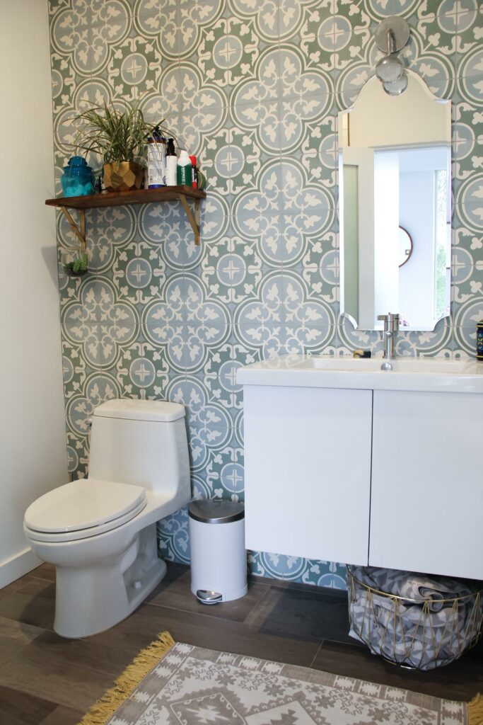 Bathroom with patterned wallpaper and modern fixtures.