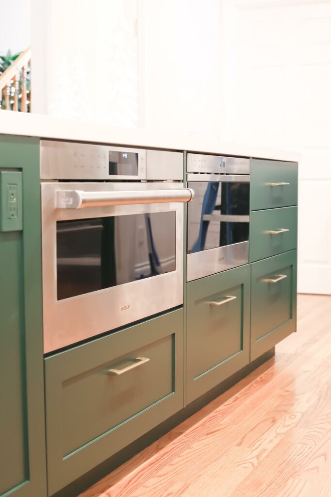 Modern green kitchen cabinets with built-in appliances.