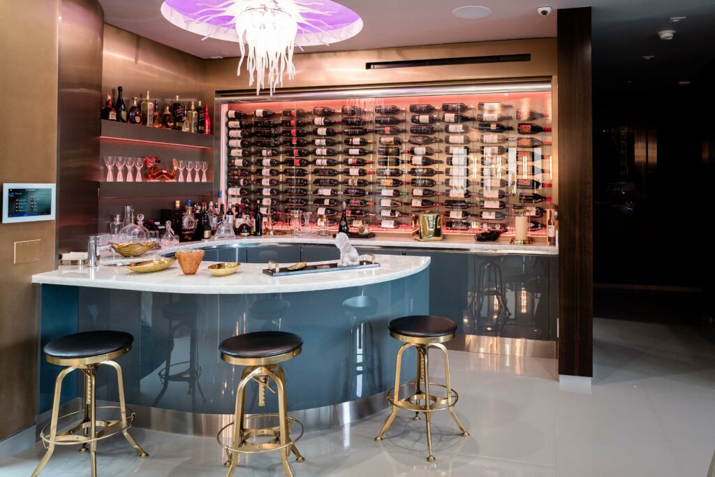 Modern home bar with stools and wine wall display.