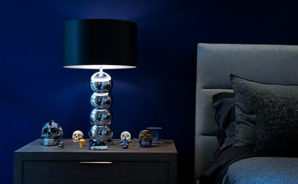 Modern bedroom with stylish lamp and decorative skulls.