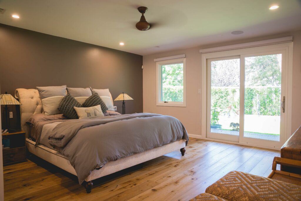 Cozy bedroom interior with hardwood floors and garden view.