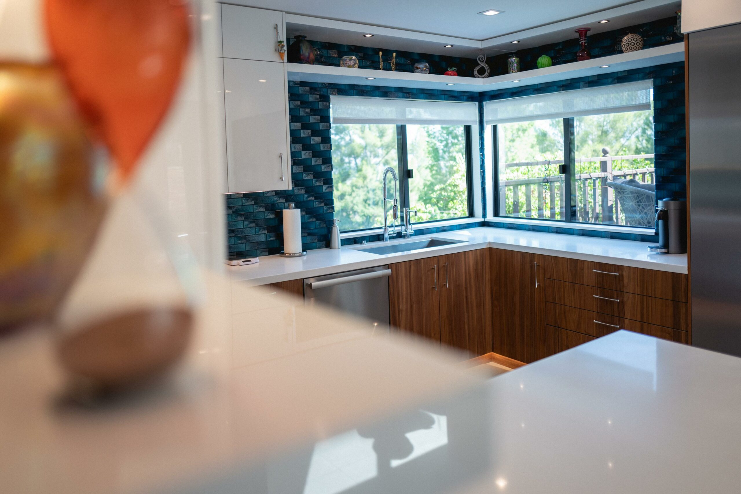Modern kitchen with blue tile backsplash and wooden cabinets.