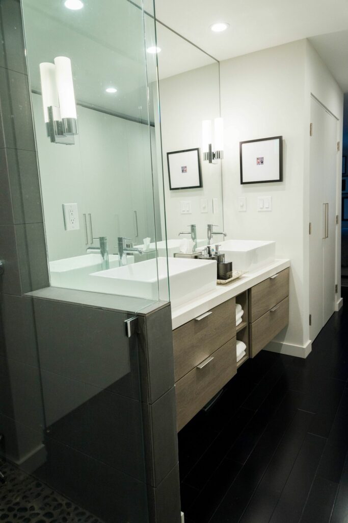 Modern bathroom with double vanity and wall sconces.