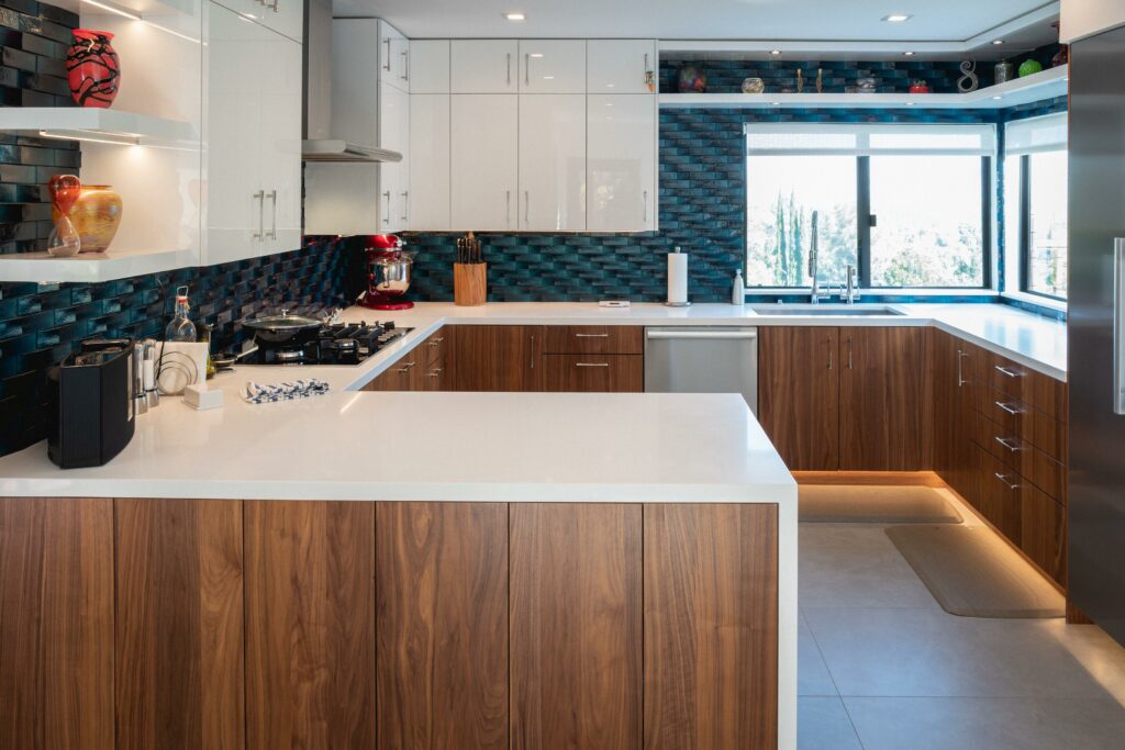 Modern kitchen interior with wooden cabinets and blue backsplash.