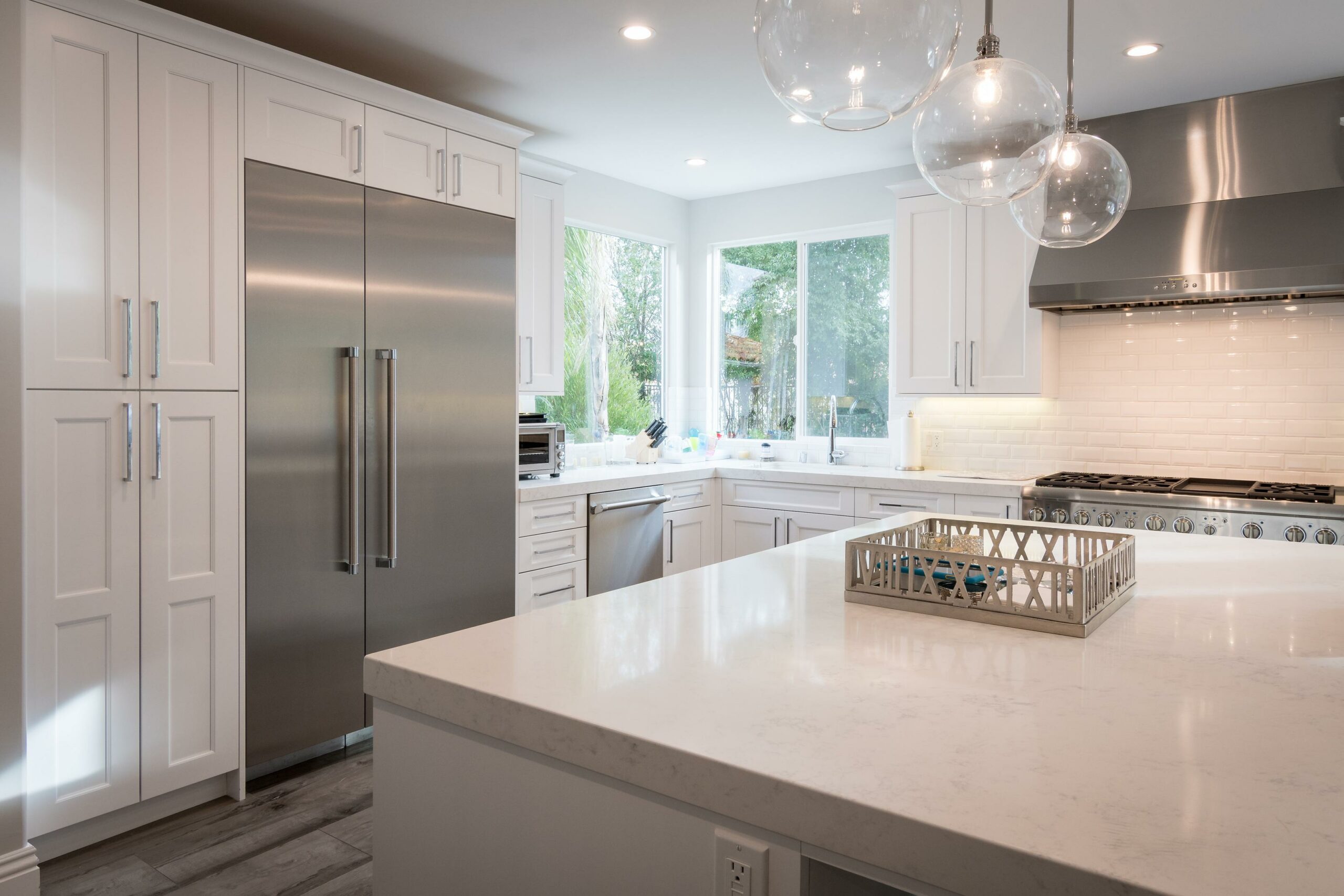 Modern kitchen with stainless steel appliances and white cabinets.