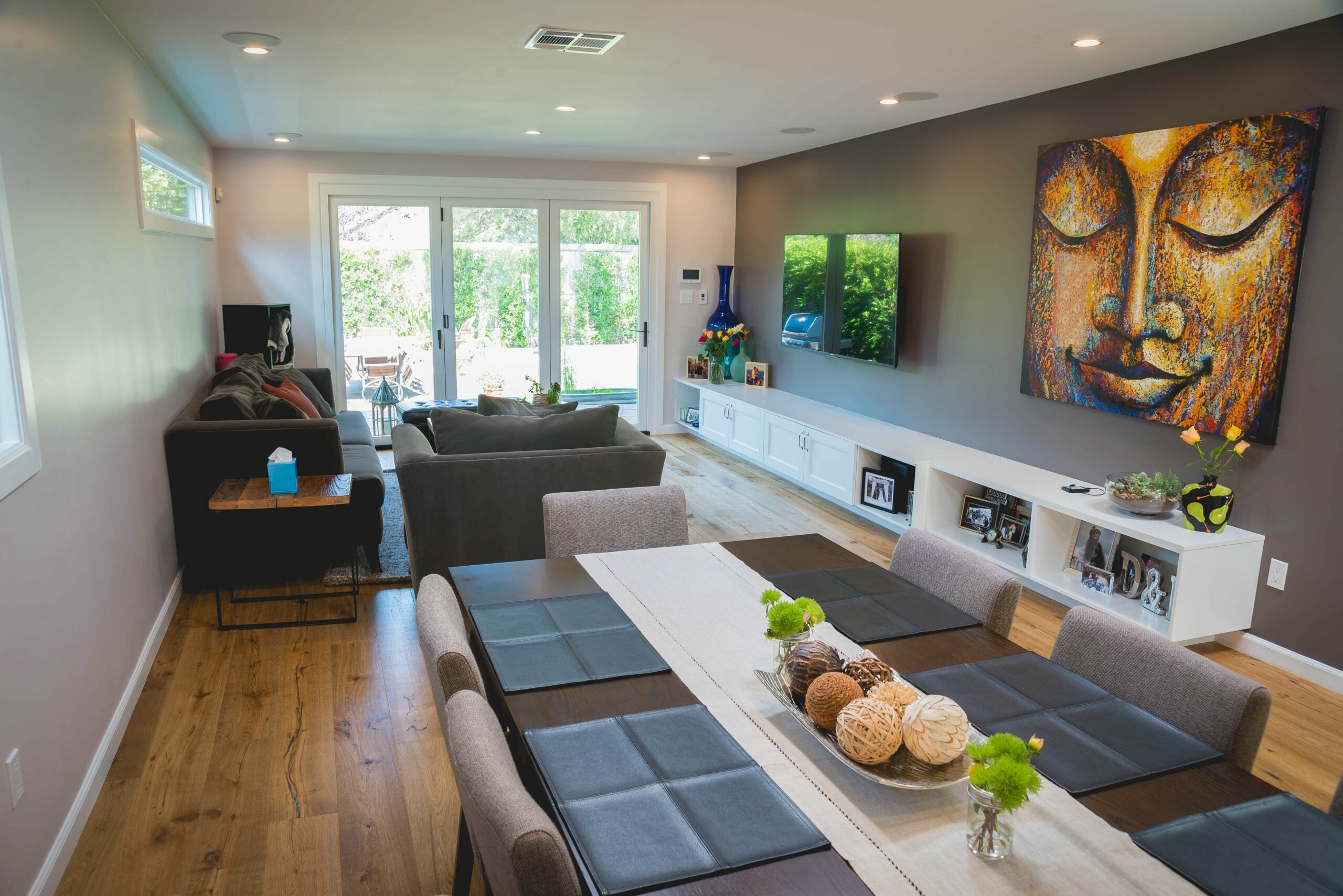 Modern living room with artwork, furniture, and hardwood floors.