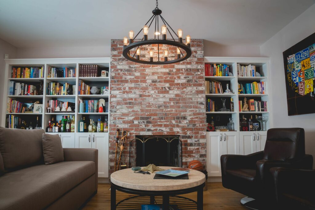 Cozy living room with brick fireplace and bookshelves.