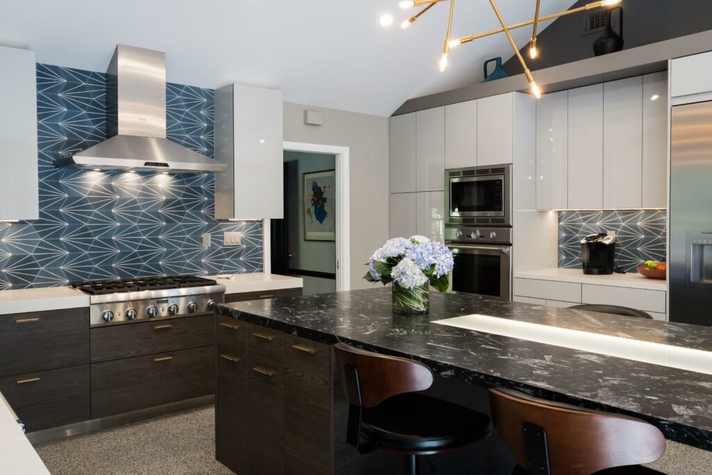 Modern kitchen with geometric backsplash and marble island.