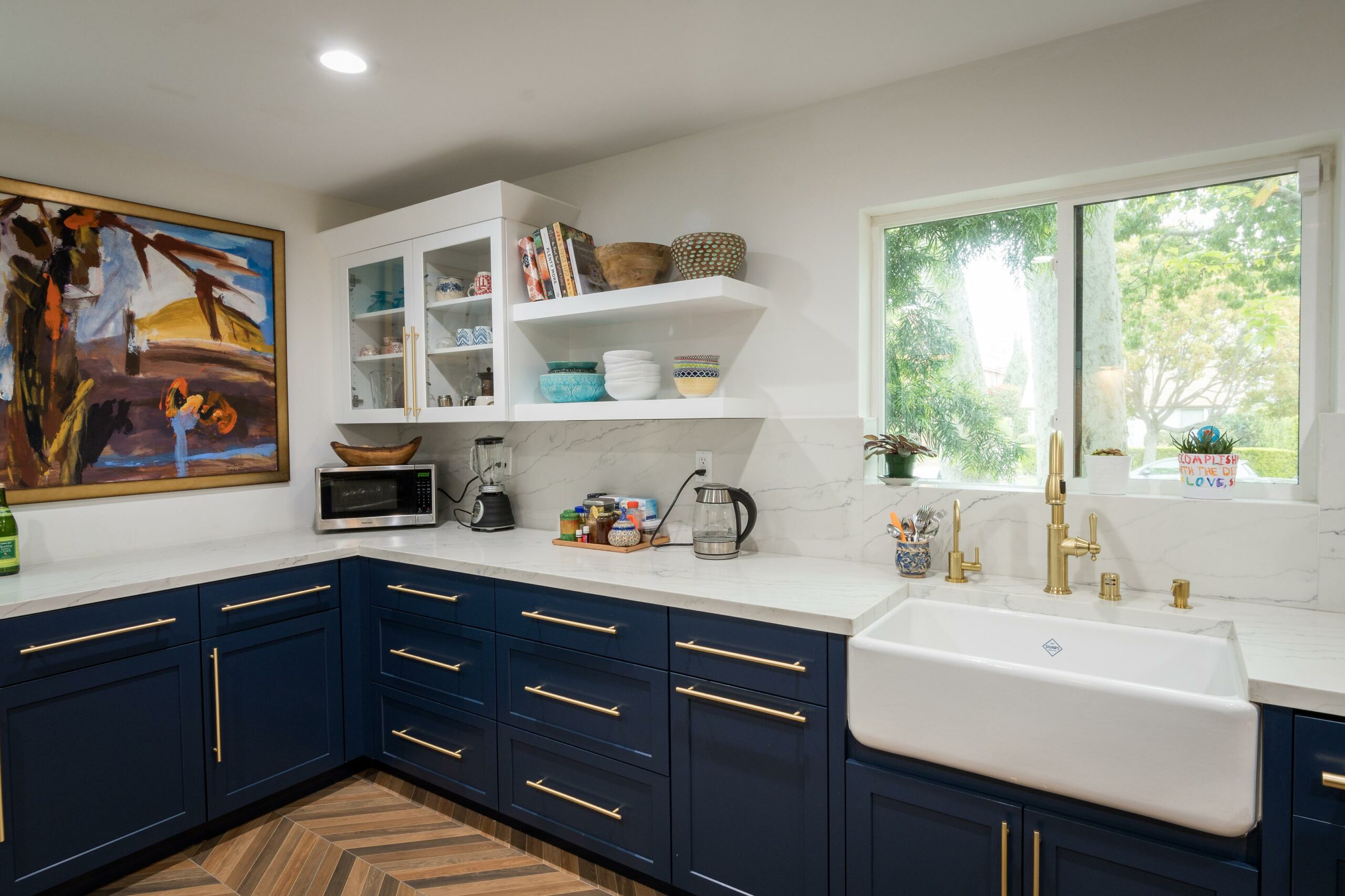 Modern kitchen with blue cabinets and marble countertops.