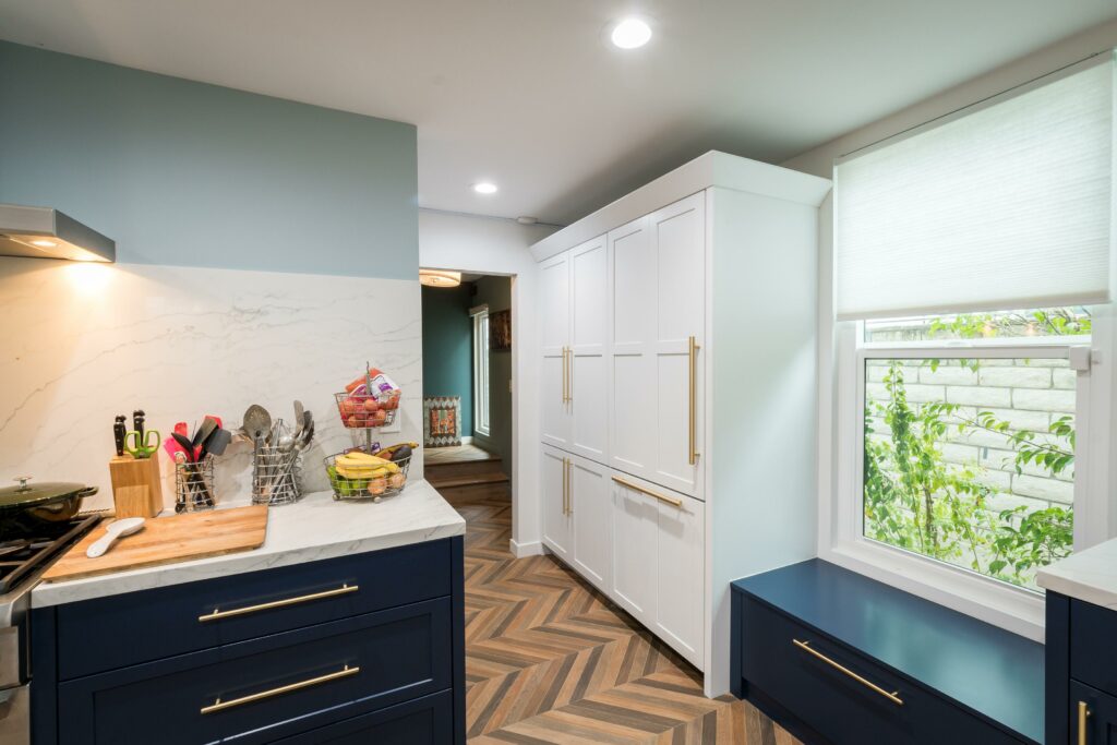 Modern kitchen with blue cabinets and herringbone floor.