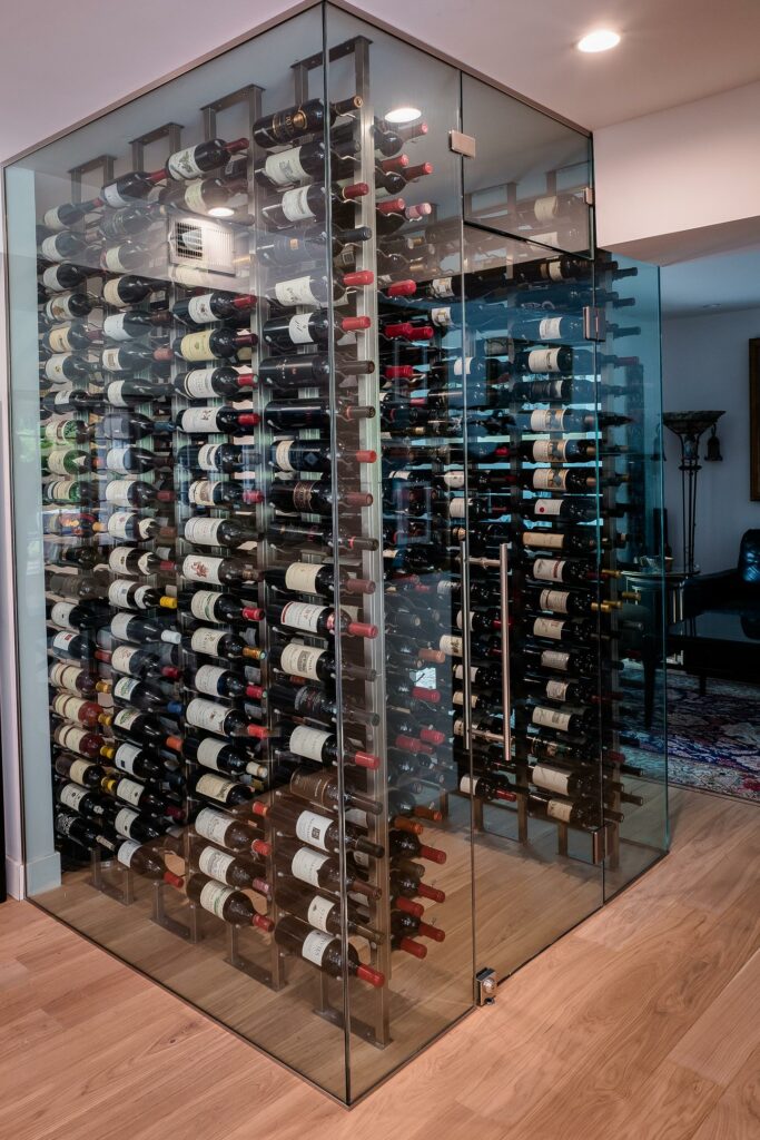 Glass wine cellar with diverse bottle collection.