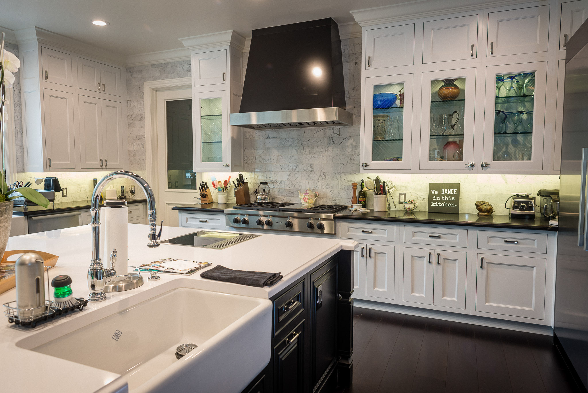 Modern kitchen with white cabinets and marble backsplash.