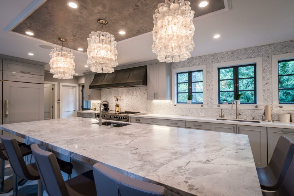 Modern kitchen interior with marble countertops and elegant lighting.