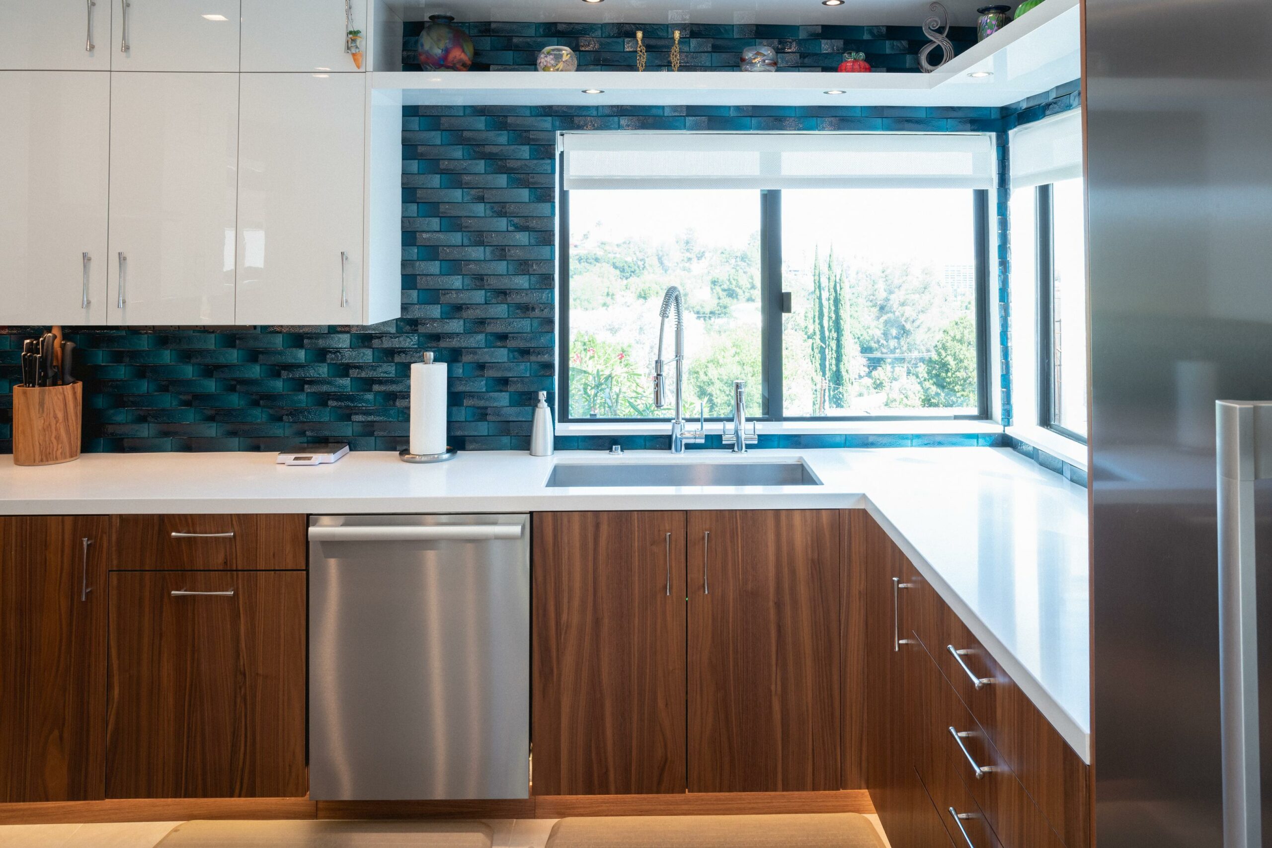 Modern kitchen with blue backsplash and wooden cabinets.