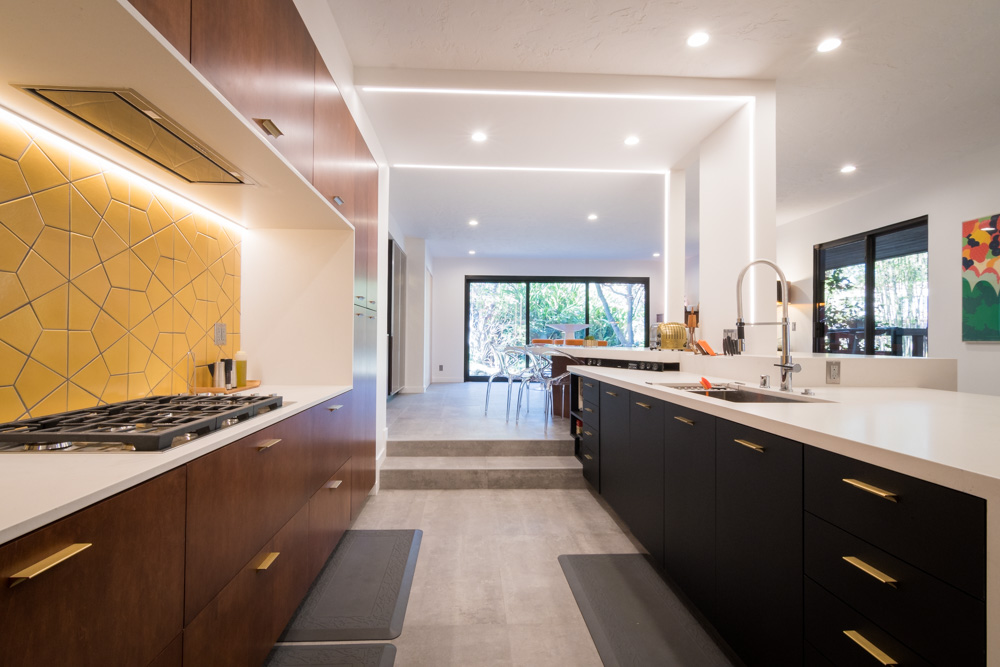 Modern kitchen interior with yellow backsplash and LED lighting.