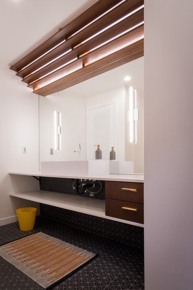 Modern bathroom interior with wooden accents and geometric tiles.