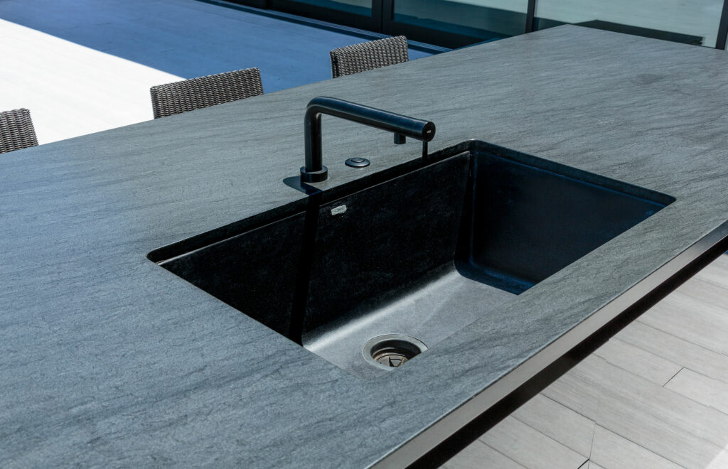 Modern kitchen sink and faucet on stone countertop