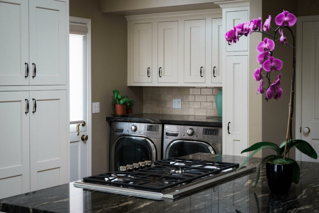 Modern kitchen with appliances and purple orchid decoration.