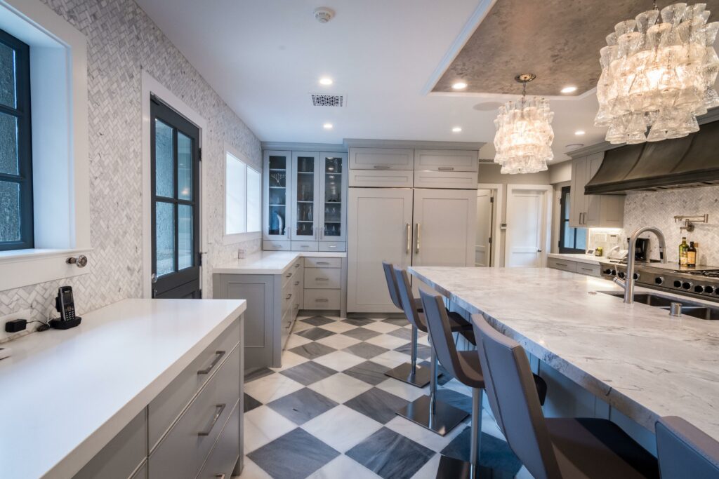 Elegant modern kitchen with checkered floor and chandeliers.