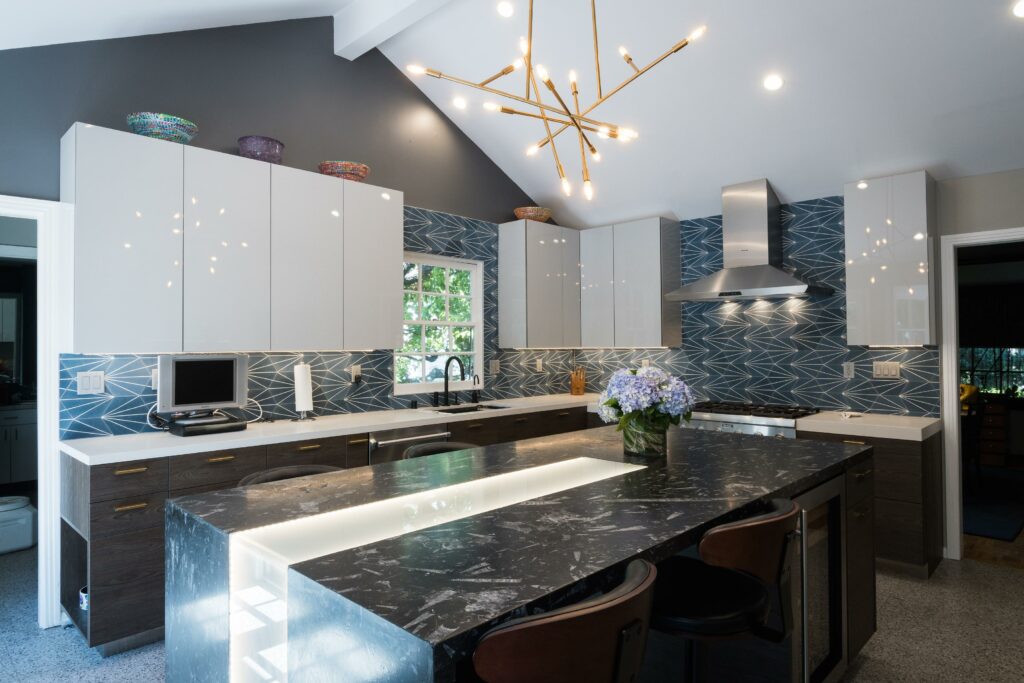 Modern kitchen with geometric backsplash and stylish pendant lights.