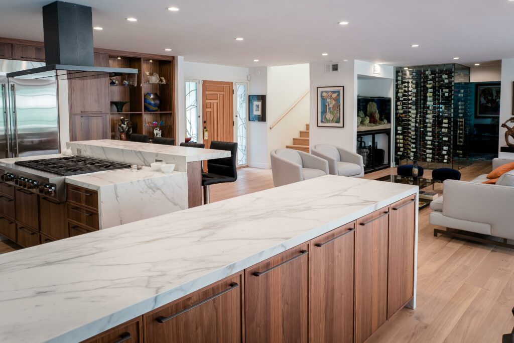 Modern kitchen with marble island and open living space.