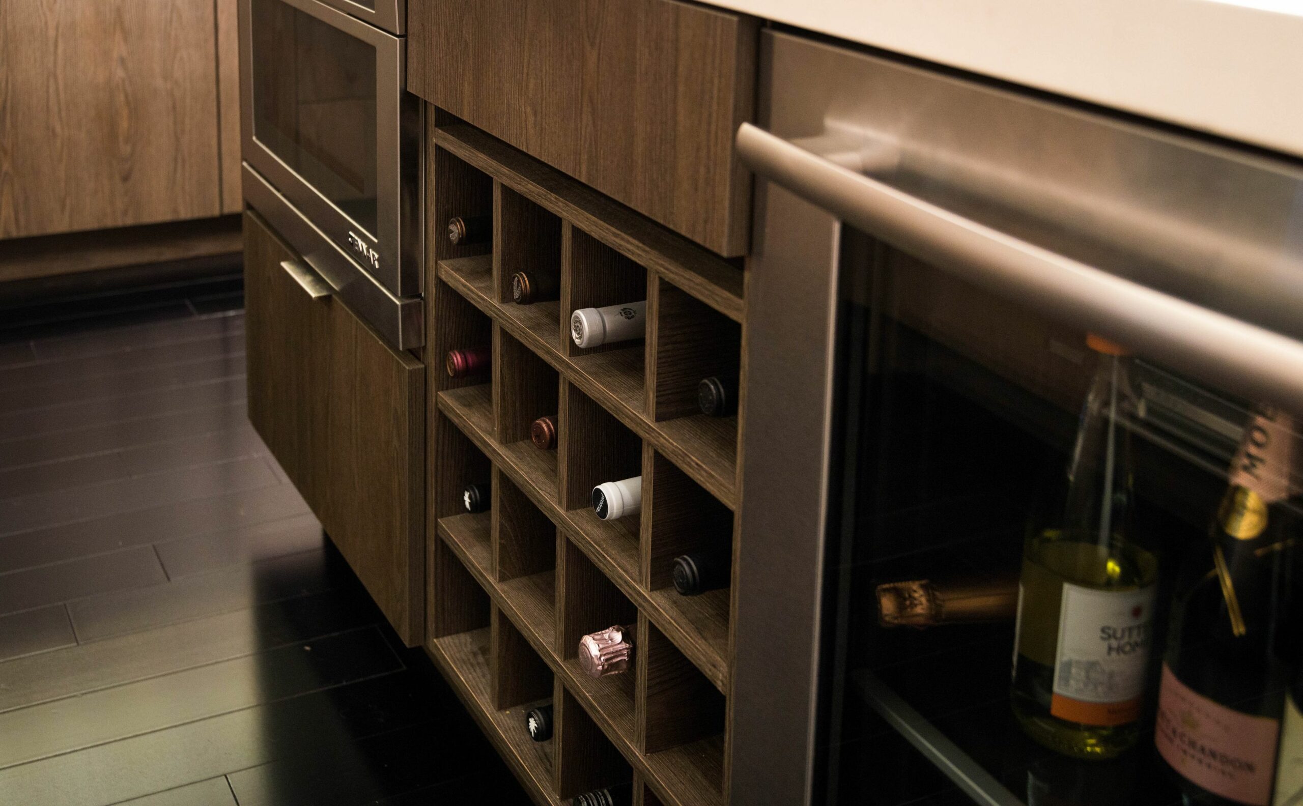Built-in wine rack beside modern oven in kitchen.