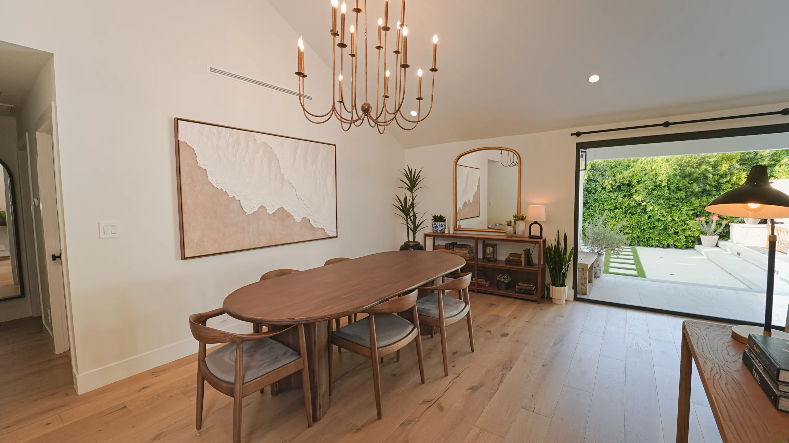 Modern dining room with wooden table and chandelier.