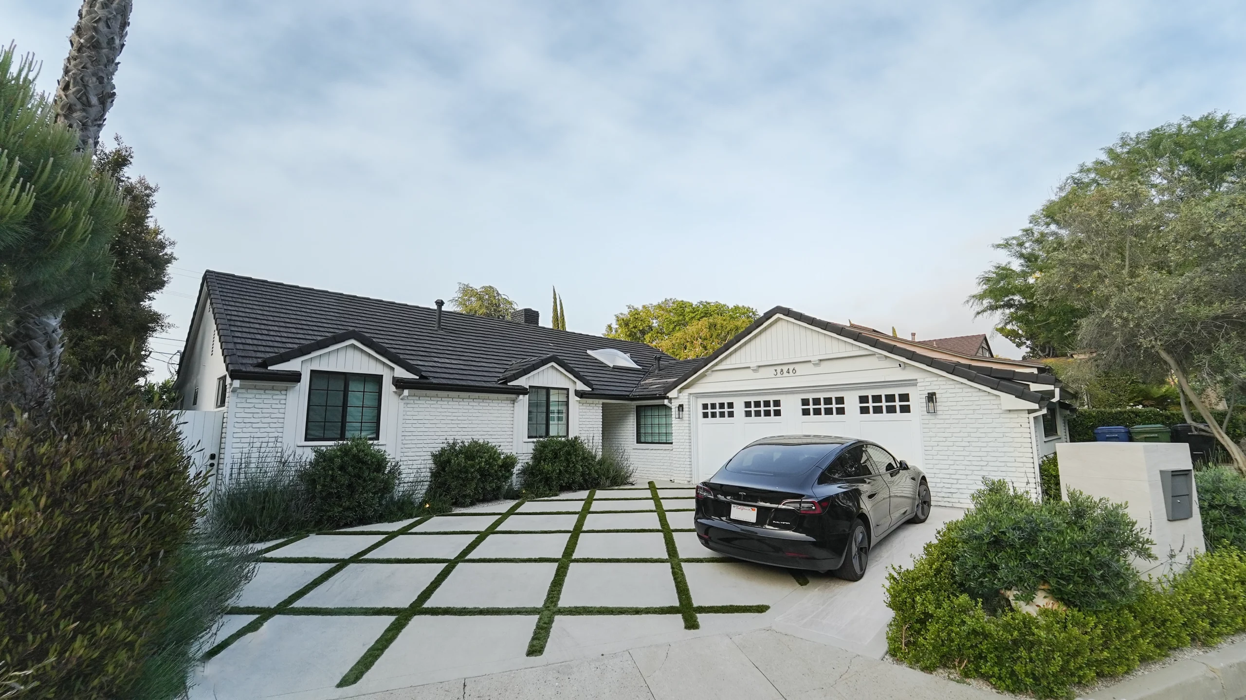White suburban house with driveway and car
