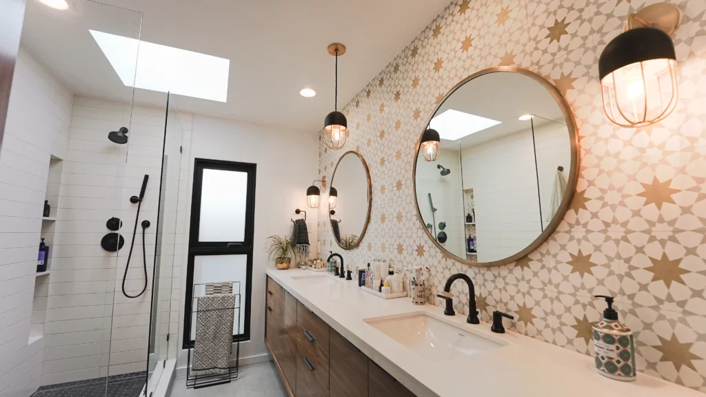 Modern bathroom interior with patterned tiles and round mirrors.